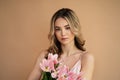 Young beautiful woman on beige background with flowers