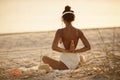 Woman in Yoga Meditation Pose with Headphones on the Beach Royalty Free Stock Photo