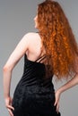 young beautiful woman in black dress with long red hairs touching herself Royalty Free Stock Photo