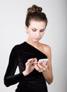 Young beautiful woman in black dress writes message to your mobile phone Royalty Free Stock Photo