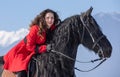 Young beautiful woman on black horse in riding in Transylvania mountains