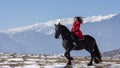 Young beautiful woman on black horse in riding in Transylvania mountains