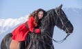 Young beautiful woman on black horse in riding in Transylvania mountains