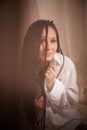 Young beautiful woman in black lace and white shirt in boudoir or bed room near white transparent tulle curtains. Adult Royalty Free Stock Photo