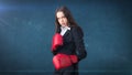 Young beautiful woman in black suit and white shirt standing in combat pose with red boxing gloves. Business concept. Royalty Free Stock Photo