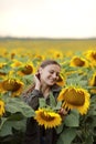 Young beautiful woman on blooming sunflower field in summer, health and lifestyle Royalty Free Stock Photo