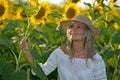 Young beautiful woman on blooming sunflower field in summer