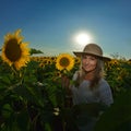 Young beautiful woman on blooming sunflower field in summer Royalty Free Stock Photo