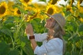 Young beautiful woman on blooming sunflower field in summer