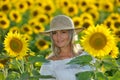 Young beautiful woman on blooming sunflower field in summer Royalty Free Stock Photo