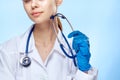 Young beautiful woman on a blue background holds a stethoscope in medical clothes, portet, medicine, doctor Royalty Free Stock Photo