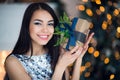 Young beautiful woman in blue elegant evening dress sitting on floor near christmas tree and presents on a new year eve Royalty Free Stock Photo