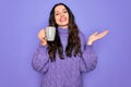 Young beautiful woman with blue eyes drinking mug of coffee over isolated purple background very happy and excited, winner Royalty Free Stock Photo