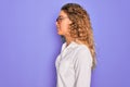 Young beautiful woman with blue eyes wearing casual shirt and glasses over purple background looking to side, relax profile pose Royalty Free Stock Photo