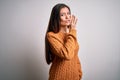 Young beautiful woman with blue eyes wearing casual sweater standing over white background hand on mouth telling secret rumor, Royalty Free Stock Photo