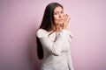 Young beautiful woman with blue eyes wearing casual white t-shirt over pink background hand on mouth telling secret rumor, Royalty Free Stock Photo