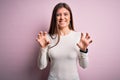 Young beautiful woman with blue eyes wearing casual white t-shirt over pink background smiling funny doing claw gesture as cat, Royalty Free Stock Photo