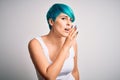 Young beautiful woman with blue fashion hair wearing casual t-shirt over white background hand on mouth telling secret rumor, Royalty Free Stock Photo