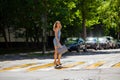Young beautiful woman in a blue short dress walking on the road Royalty Free Stock Photo