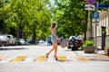 Young beautiful woman in a blue short dress walking on the road Royalty Free Stock Photo