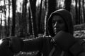 Young beautiful woman boxer in a tracksuit with a hood on his head in red boxing gloves trains in the forest in nature Royalty Free Stock Photo