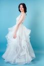 Young and beautiful woman bride with makeup in long chic white wedding dress in studio on a blue background. concept of Royalty Free Stock Photo