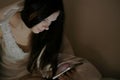 Young beautiful woman brunette browsing internet in her mobile phone in bed before sleeping. Royalty Free Stock Photo