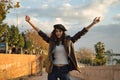 Young and beautiful woman, brunette, with curly hair, with leather jacket and black beret, with open arms and seductive look. Royalty Free Stock Photo