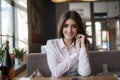 Young beautiful woman, brunette, sitting alone at a table in a cafe Royalty Free Stock Photo