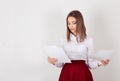 Young beautiful woman in a business clothes, reading some documents, paperwork. One single person isolated white wall background. Royalty Free Stock Photo