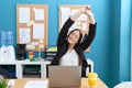 Young beautiful woman business worker tired stretching arms at office