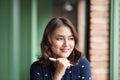 Young beautiful woman in the cafe near the window, thinking and writing something. Royalty Free Stock Photo