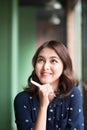 Young beautiful woman in the cafe near the window, thinking and writing something. Royalty Free Stock Photo