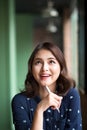 Young beautiful woman in the cafe near the window, thinking and writing something Royalty Free Stock Photo