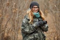 Young beautiful woman in camouflage outfit discovering nature in the forest with photo camera. Travel photography lifestyle Royalty Free Stock Photo