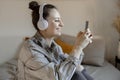 Young beautiful woman with casual clothes sitting on the bed at home and making selfie on smartphone. Girl using mobile Royalty Free Stock Photo