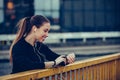 Sporty girl checking progress on smart watch on the bridge Royalty Free Stock Photo