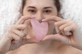 Young and beautiful woman during Chinese traditional massage - Gua Sha with stone in heart shape in hand. Close-up photo. Beauty Royalty Free Stock Photo