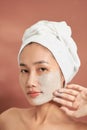 Young beautiful woman with clay face mask. Spa treatment, self care and healthy skin Royalty Free Stock Photo