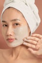 Young beautiful woman with clay face mask. Spa treatment, self care and healthy skin Royalty Free Stock Photo