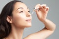 Young beautiful woman with clean perfect skin uses age-sensitive serum in pipette Royalty Free Stock Photo