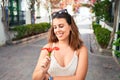 Young beautiful woman at the colorful village of Puerto de Mogan, smiling happy smelling flower on the street on summer holidays Royalty Free Stock Photo