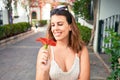 Young beautiful woman at the colorful village of Puerto de Mogan, smiling happy smelling flower on the street on summer holidays Royalty Free Stock Photo