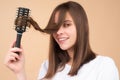 Young beautiful woman combing brown hair. Hair Care. Beautiful brunette woman hairbrushing hair with hairbrush. Brushing Royalty Free Stock Photo