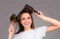 Young beautiful woman combing brown hair. Hair Care. Beautiful brunette woman hairbrushing hair with hairbrush. Brushing Royalty Free Stock Photo