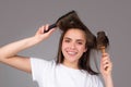 Young beautiful woman combing brown hair. Hair Care. Beautiful brunette woman hairbrushing hair with hairbrush. Brushing Royalty Free Stock Photo