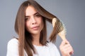 Young beautiful woman combing brown hair. Hair Care. Beautiful brunette woman hairbrushing hair with hairbrush. Brushing Royalty Free Stock Photo