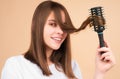 Young beautiful woman combing brown hair. Hair Care. Beautiful brunette woman hairbrushing hair with hairbrush. Brushing Royalty Free Stock Photo