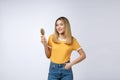 Young beautiful woman combing her hair isolated over grey background. Royalty Free Stock Photo