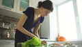 Young beautiful woman cook cutting the mushrooms on wooden board for pizza in the kitchen at home Royalty Free Stock Photo